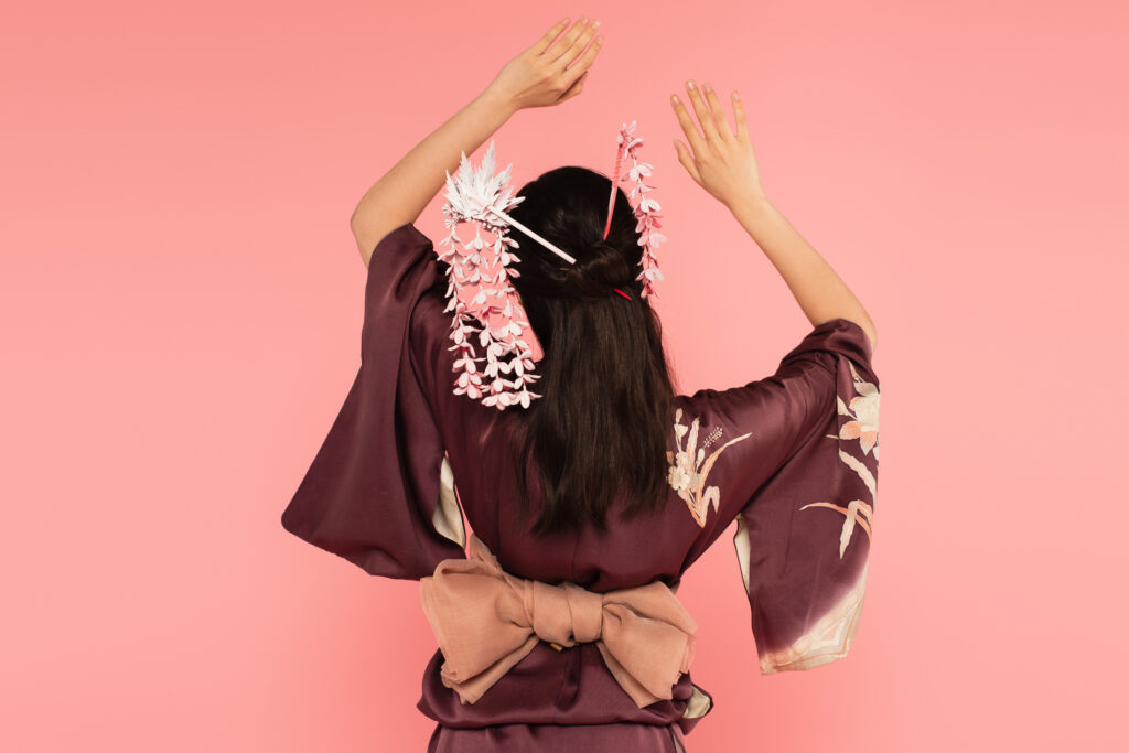 back view of woman with oriental hairdo isolated on pink