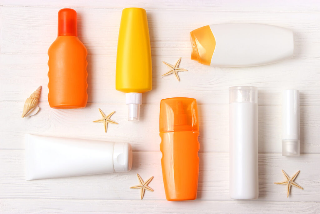 seashells and sunscreen on a colored background top view. sunscreen