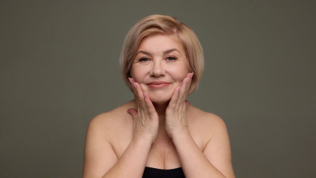 mature woman holding face anti aging skincare portrait.