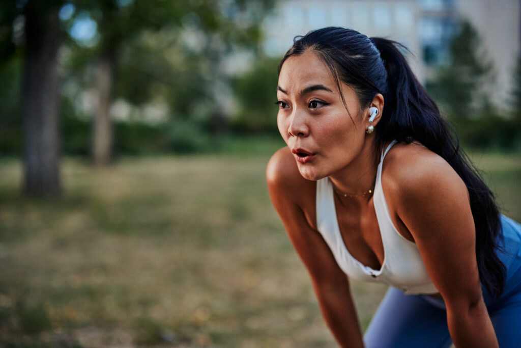 asian woman taking a moment to catch her breath after workout in
