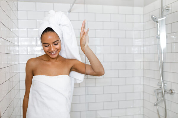 young woman in white towels wrapped around head and body after shower
