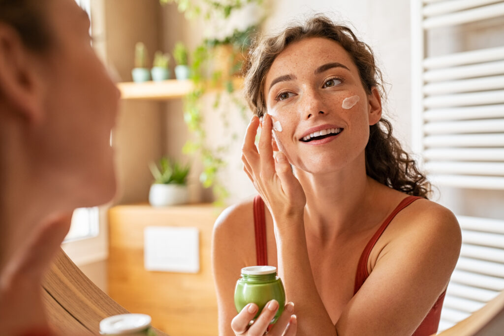woman applying moisturiser on face during morning routine